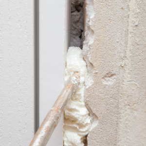 spray-gun-filling-gap-with-construction-foam-between-new-door-and-wall-closeup-repair-work-of