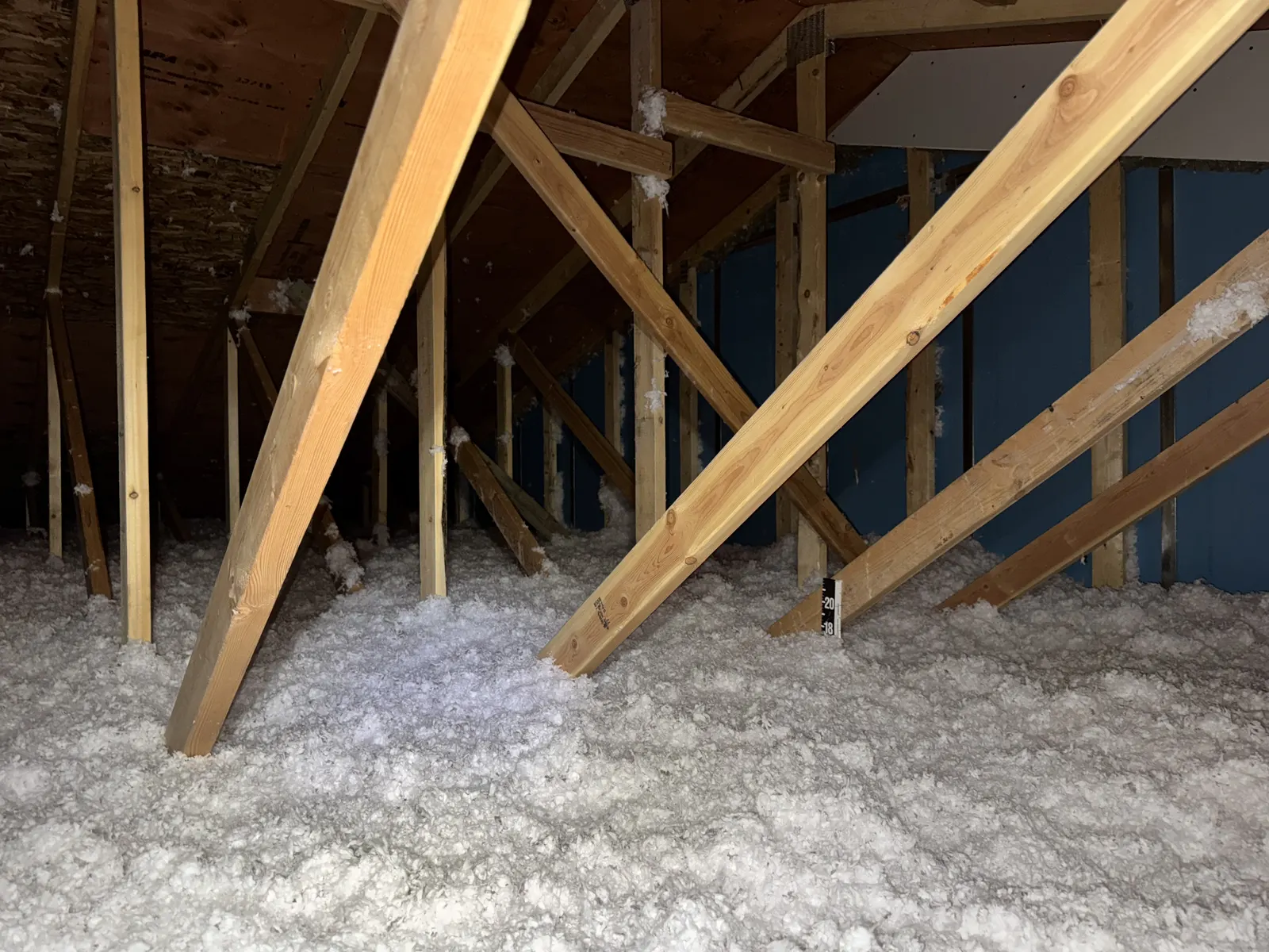 Loose-fill insulation surrounding attic framing and diagonal roof bracing