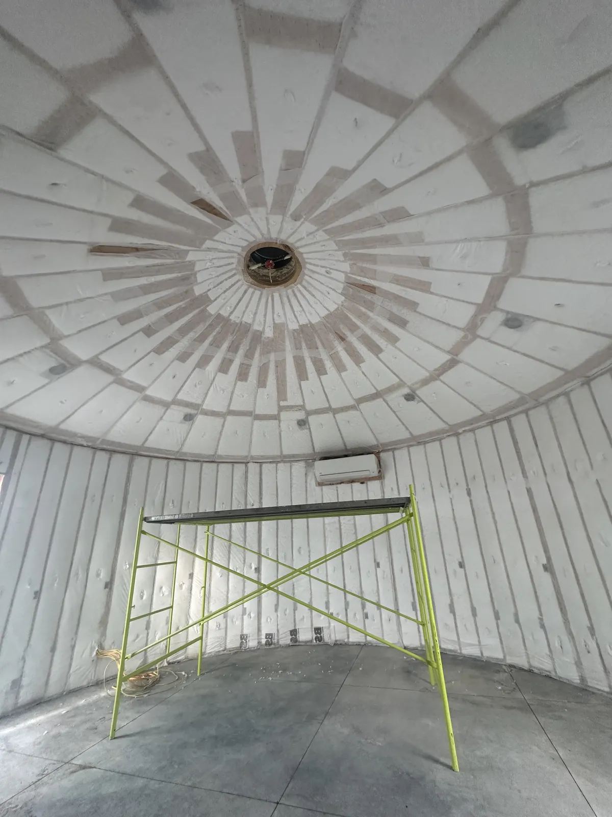 Insulated circular room with ceiling framing radiating toward a central opening