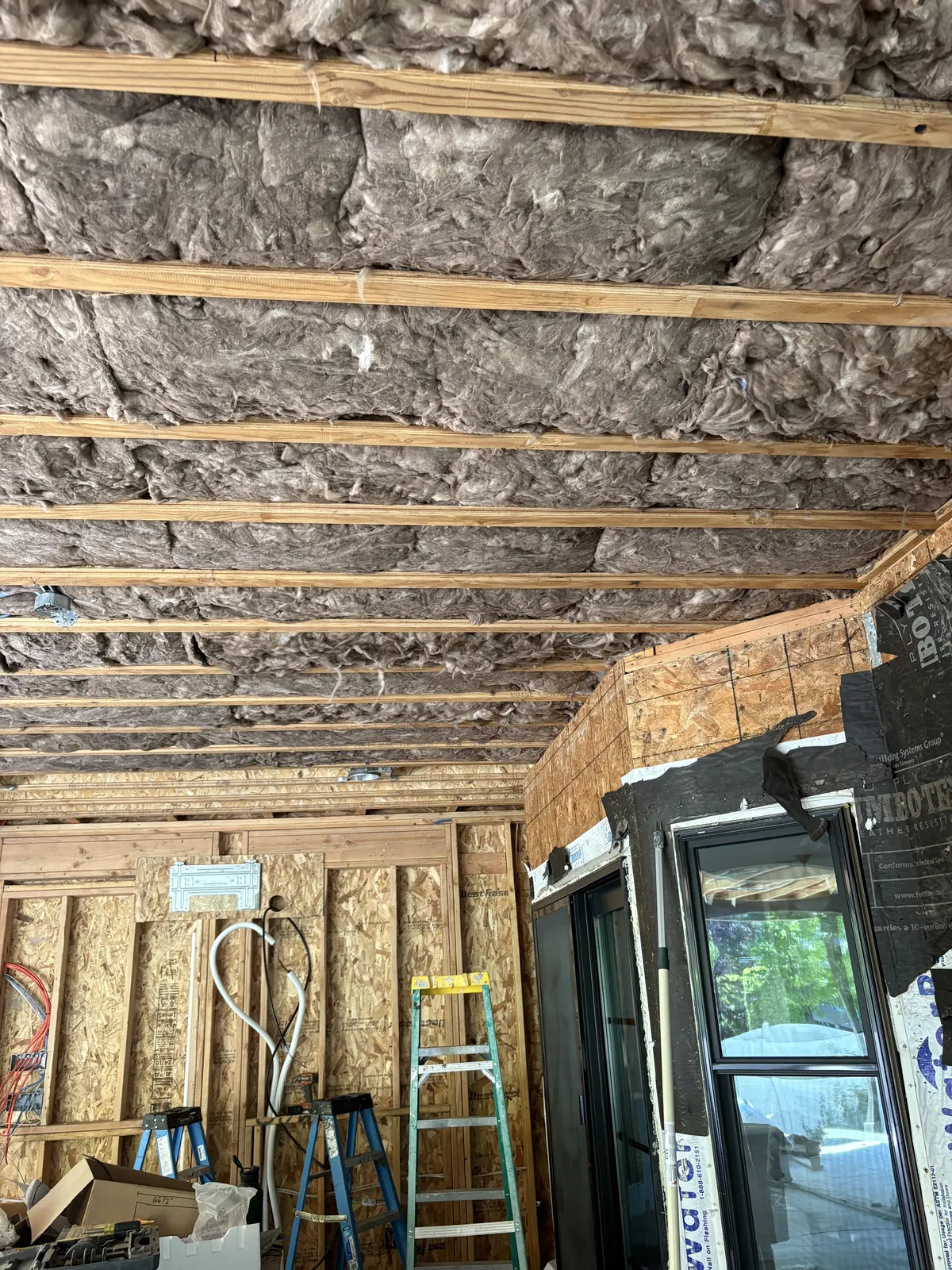 Residential ceiling and wall framing prepared for insulation during construction