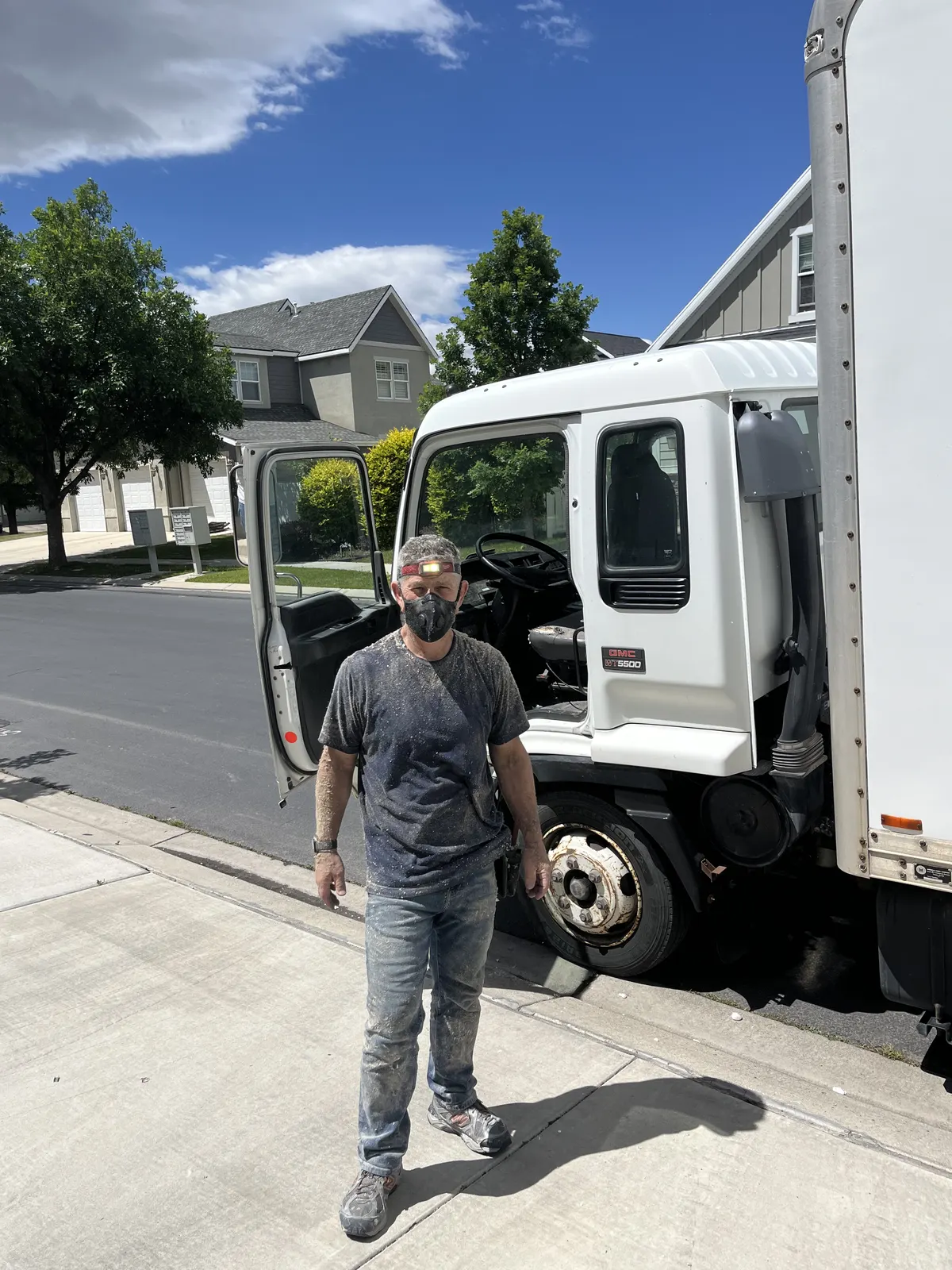Interwest insulation installer standing beside the work truck at a residential project