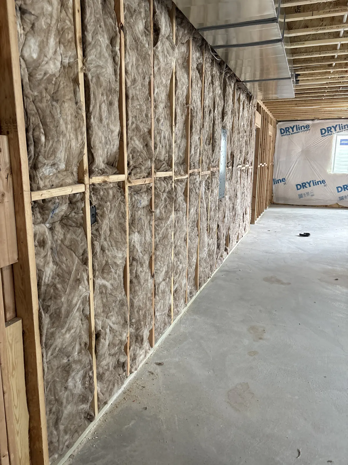 Insulation installed throughout a long open-framed residential wall