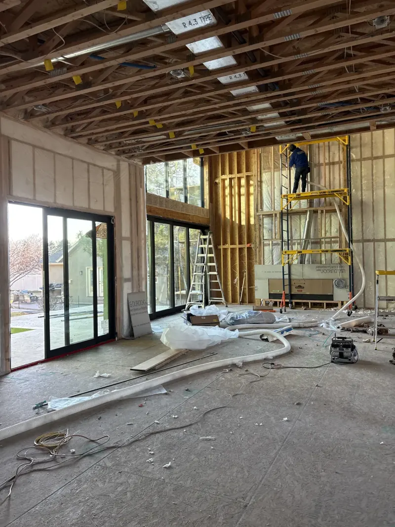 Installer working from scaffold in the open framing of a custom residential project