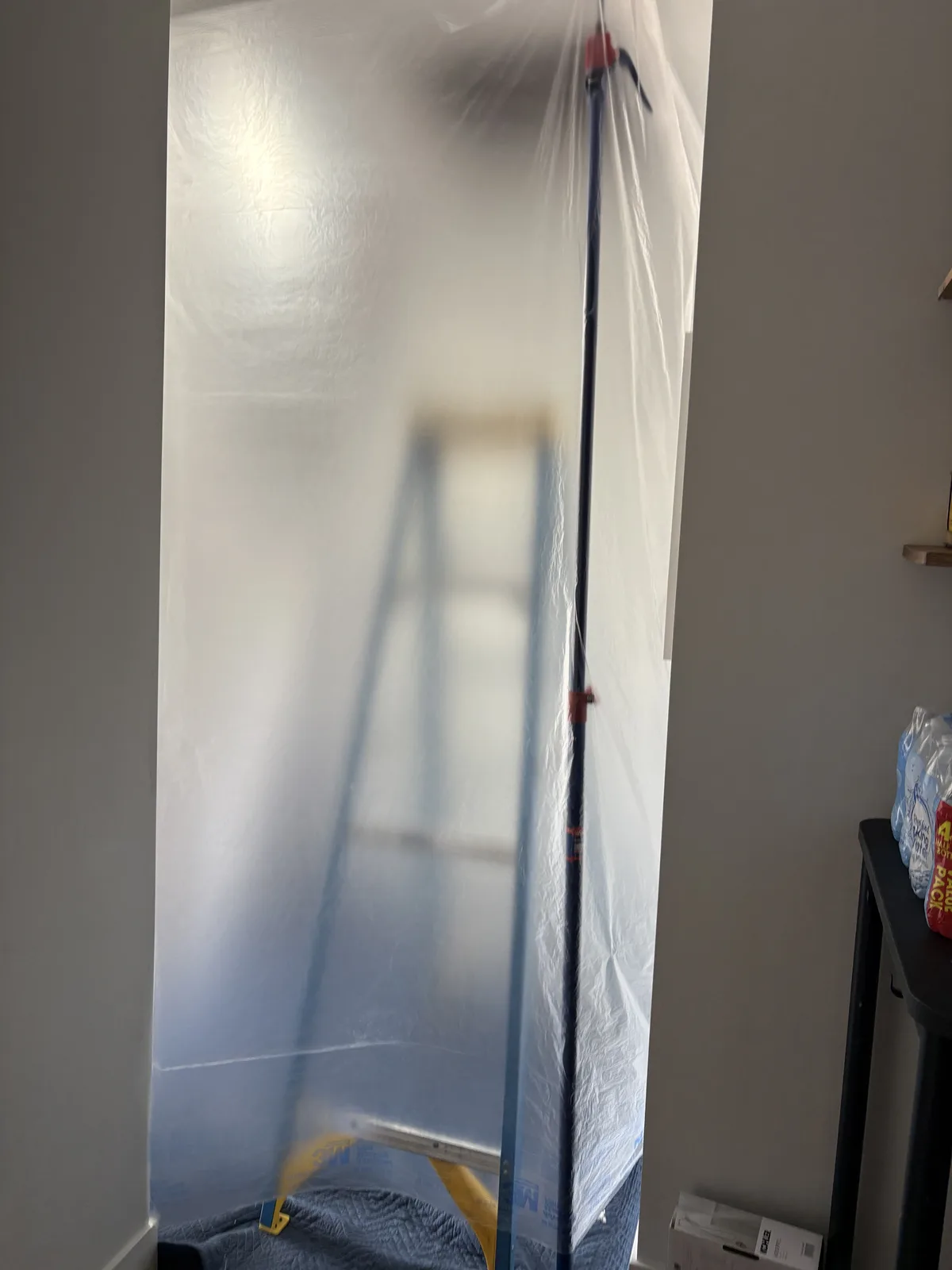 Plastic containment wall separating a living room from the insulation work area