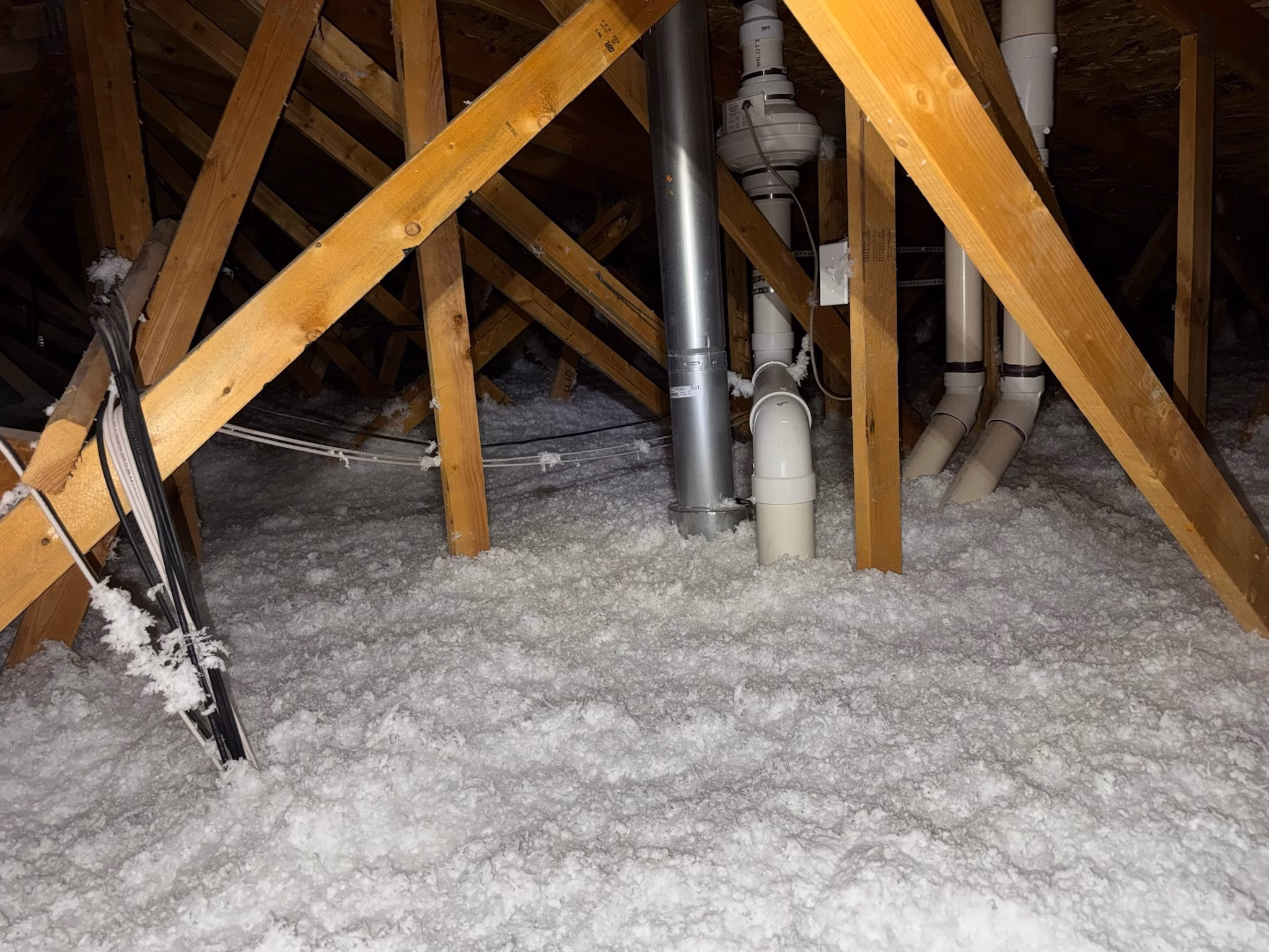 Blown fiberglass insulation around roof trusses in a Draper attic