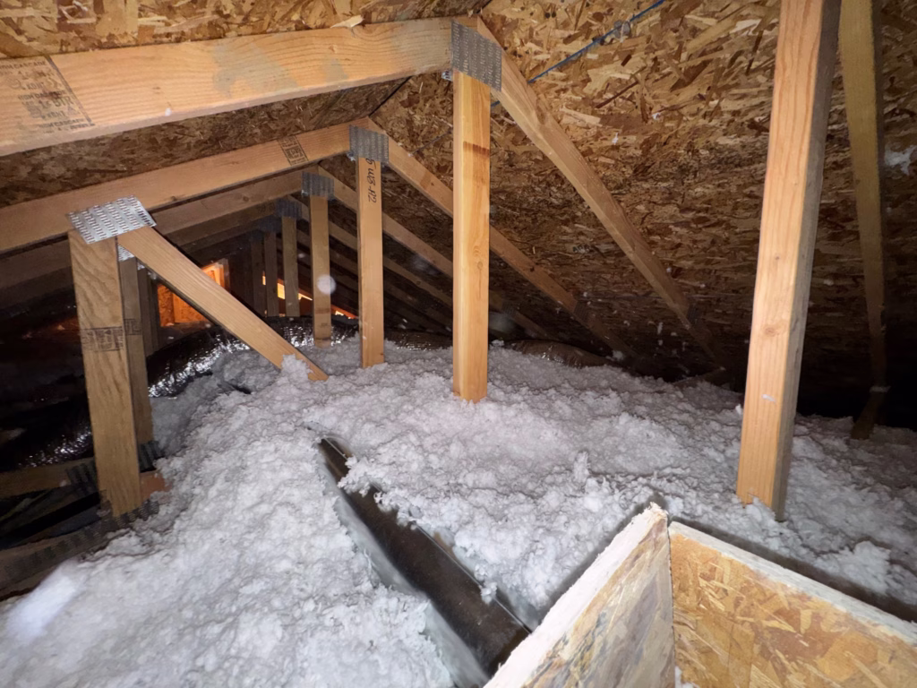 Loose-fill attic insulation around roof trusses in Magna, Utah